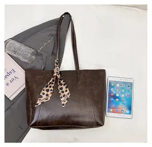 Large dark brown tote bag with leopard scarf shown next to an iPad for size comparison