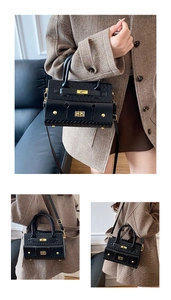 Détail du sac à main noir tressé avec fermoir rotatif doré et bandoulière réglable