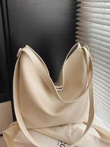 Minimalist beige pebble leather bucket tote bag with spacious interior and wide strap