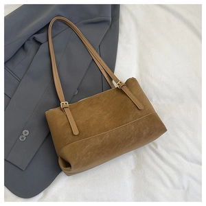 Close-up of vintage brown tote bag with adjustable straps and matte texture finish