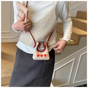 Detail van mini crème crossbodytas met rode polkadots en 3D-bloemdecoraties