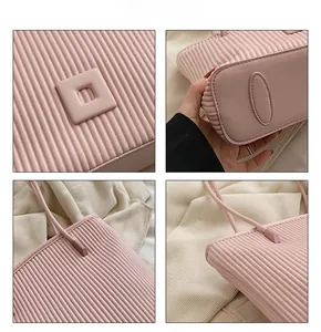 Detail view of pink tote bag showing vertical pleated texture and reinforced base structure