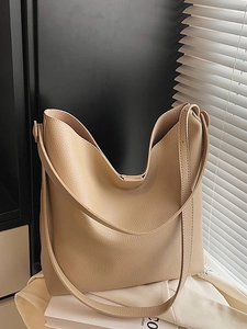 Minimalist beige litchi grain hobo tote bag with a soft leather shoulder strap