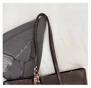 Detail of dark brown tote handle with decorative leopard print silk scarf wrap