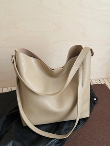 Minimalist apricot large capacity tote bag with lychee texture on black leather jacket