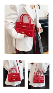 Détail du sac rouge avec texture tressée et fermoir pivotant en métal doré