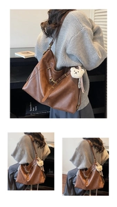 Detailed view of brown leather tote bag texture with metal buckle and cute bear charm