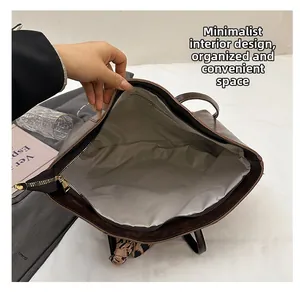 Close-up of spacious interior compartment and smooth zipper of the brown leather tote bag