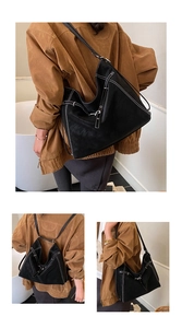 Detail of black faux leather tote bag with white contrast stitching and slim straps