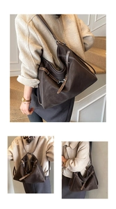 Detail of vintage brown leather tote bag with white contrast stitching and buckle straps