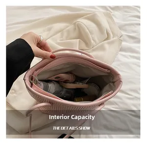 Spacious interior of pink pleated tote bag holding folding umbrella and cosmetics