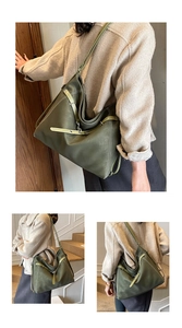 Detail of dark green matte tote bag with olive straps and contrast white stitching accents