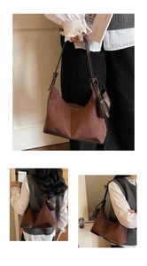 Detail of brown suede hobo bag with leather patchwork and mini coin purse charm