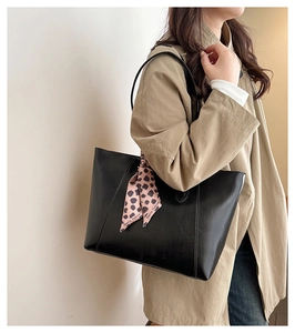 Detail of black large capacity tote bag in glossy leather with leopard print scarf accent
