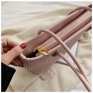 Détail du sac fourre-tout plissé rose avec fermeture éclair dorée et poignée lisse