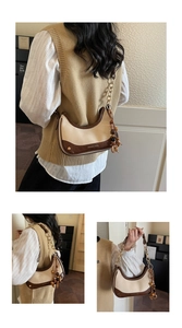 Detail of contrast half-moon bag with gold chain strap and decorative wooden beads