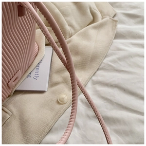 Détail du sac cabas à rayures roses avec bandoulière en cuir et breloque minimaliste