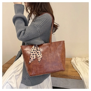 Detail showing vintage brown tote bag with a polka dot silk scarf on the handle