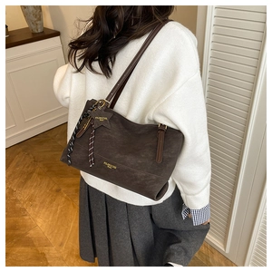Detail of dark brown matte tote bag with star charm and metallic brand logo