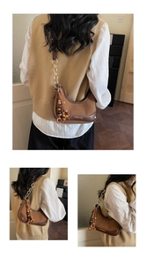Detail of vintage brown patchwork hobo bag with wooden bead fringe and gold chain strap