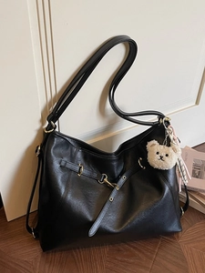 Minimalist black faux leather tote bag with gold hardware and white bear charm
