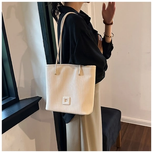 Détail du grand sac cabas rayé blanc avec texture plissée verticale et doubles bandoulières
