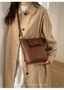 Brown retro bucket bag with spherical pendants shown in a minimalist commute scene