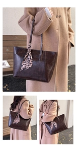 Detail of vintage brown tote bag with leopard silk scarf tied on the handle