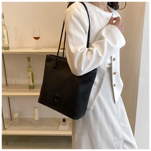 Détail du grand sac cabas noir plissé à rayures verticales dans un cadre de vie minimaliste