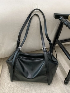 Elegant black leather tote bag with silver zipper and adjustable shoulder straps