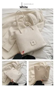 Close-up of white striped tote bag with pleated texture and metallic feet detailing