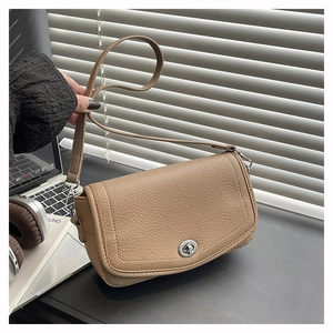 Close-up of khaki lychee texture leather handbag with silver twist lock and strap