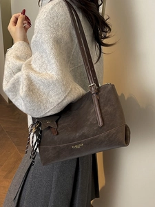 Vintage dark brown oversized tote bag with star charm and fringe tassels on a model