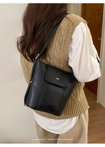 Minimalist black leather pumpkin bucket bag with gold metal trim and flip cover