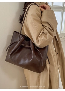 Minimalist dark brown leather tote bag featuring a decorative drawstring knot detail