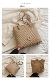 Detail view of khaki striped tote bag with vertical pleated texture and bottom feet studs