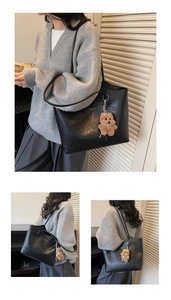 Detail of black tote bag with lychee leather texture and cute brown teddy dog pendant