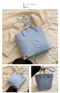 Detailed view of light blue tote bag with vertical pleats and chic square texture design