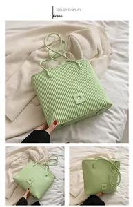 Detail view of the vertical pleated texture and leather straps on this green tote bag