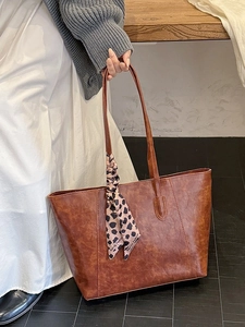 Vintage caramel brown large capacity tote bag with leopard print scarf on wood background