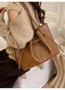 Caramel leather tote bag detail with drawstring design and soft wrinkled texture