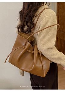 Chic caramel oversized tote bag with retro drawstring and knot detail shown on shoulder