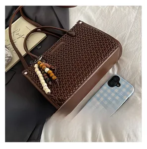 Close-up of brown woven texture handbag with colorful wood bead tassels and straps