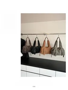 Detail of four vintage tote bags with metallic rivets in coffee, black, brown, and grey