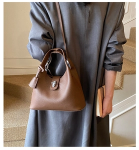 Detail of brown lychee grain leather bucket bag with silver lock and pendant