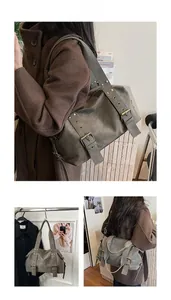 Detail view of large grey tote bag featuring vintage rivets and buckle straps
