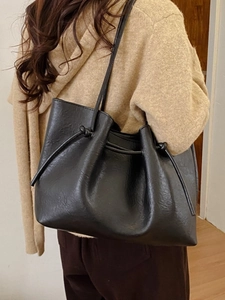 Minimalist black tote bag with drawstring detail and slim straps for daily commute