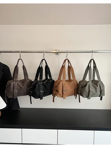 Detail view of four vintage leather tote bags in brown, black, camel, and green