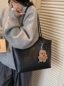 Retro black leather tote bag with large capacity and brown plush charm on model