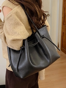 Black large capacity faux leather tote bag with drawstring detail and slim shoulder strap